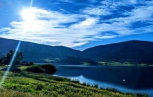 an image iof a lake with mountains in the background
