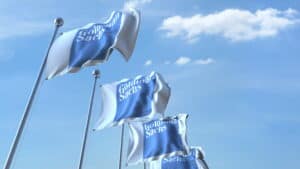 picture of four goldman sachs flags raised on poles against a blue sky