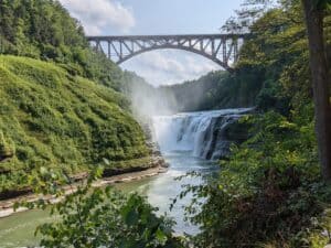image of a bridge over a river and waterfall in a subtropical climatic area