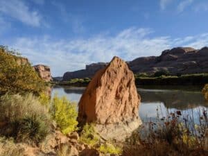 image of a body of water surrounded by large rocks and foliage